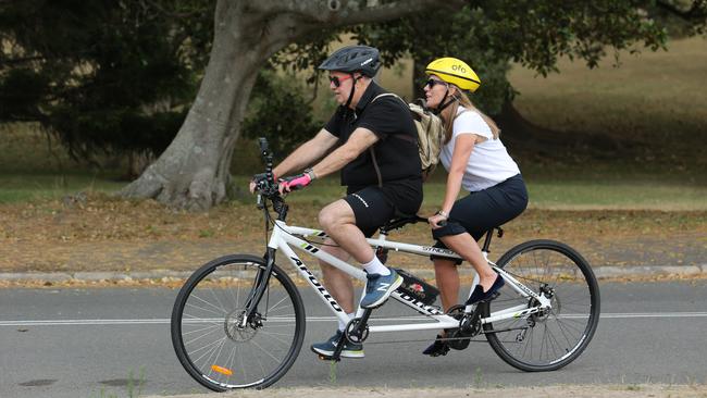 The Australian's reporters Chris Griffith and Caroline Overington trialling an electric tandem bike in Centennial Park in Sydney in 2019. Picture: Britta Campion