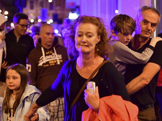 People run down Borough High Street as police are dealing with an incident on London Bridge in London. Picture: PA via AP