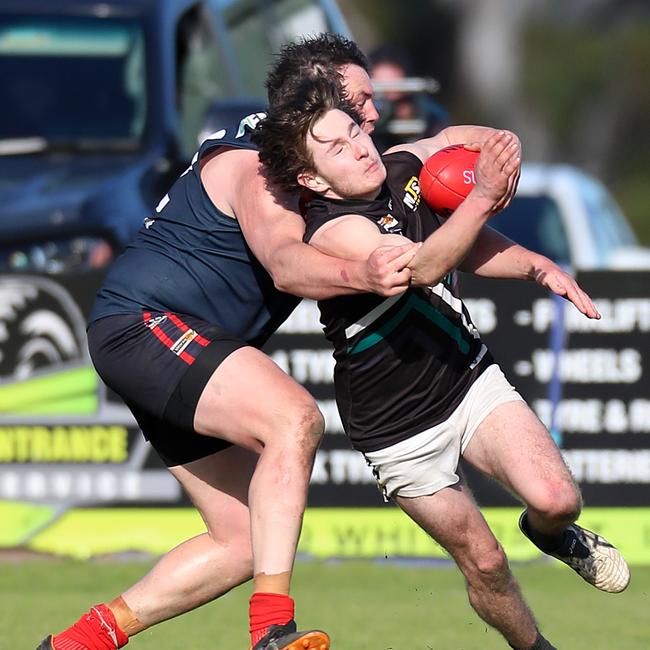 Swifts Creek’s Andrew Sandy tackles Omeo-Benambra’s William Cook.