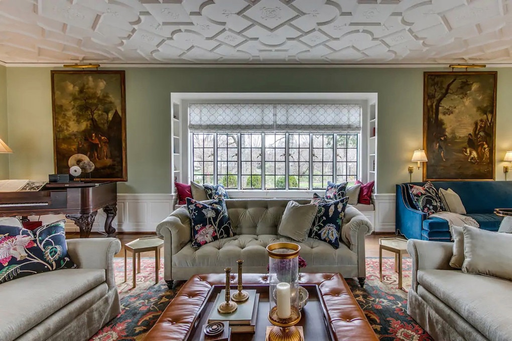 A light-green drawing room has moulded plaster ceilings and a huge, steel-windowed reading nook. Picture: Airbnb