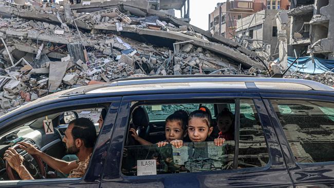 Palestinians drive amid the rubble of buildings destroyed in an Israeli air strike in Rafah, on the southern Gaza Strip. Picture: Said Khatib / AFP