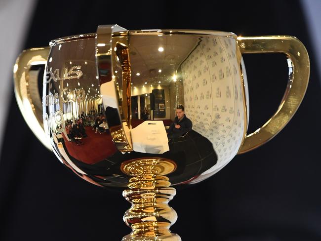 Tom Palin of the Raymond Tusk ownership syndicate is seen in the reflection of The Melbourne Cup trophy during the press conference after a trackwork session at Werribee Racecourse in Werribee, Sunday, November 3, 2019. (AAP Image/Vince Caligiuri) NO ARCHIVING