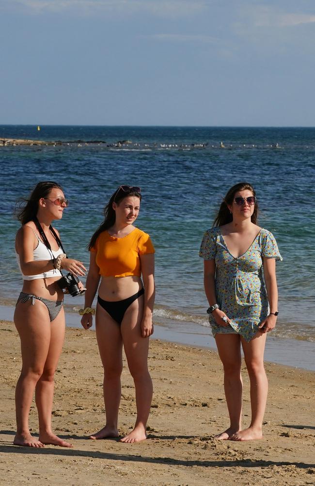 Police officers inform beachgoers that the beach is closed at Brighton Beach in Melbourne, Saturday, March 28, 2020. Picture: Scott Barbour