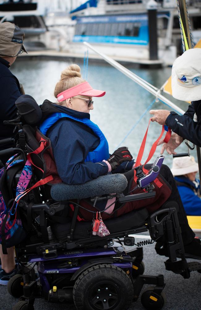 Sharon Dalton uses a sling with the help of volunteers to place herself into a boat. Photo: RSL