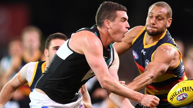 Port Adelaide’s Tom Rockliff of Port Adelaide handballs under pressure from Cam Ellis-Yoleman of the Crows in round 20. Picture: Mark Brake/Getty Images