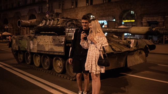 A couple takes a selfie by burnt-out Russian military vehicles displayed in the downtown area in Kyiv, Ukraine. Picture: Alexey Furman/Getty Images