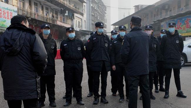 Security guards stand in front of the closed Huanan wholesale seafood market in Wuhan. Picture; AFP.