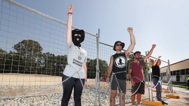 Black Swan Lake protest at Bundall goes to another level, with protesters chaining themselves to the fence and then getting themselves arrested after running onto the worksite and stopping the trucks. Protesters chained to the fence. Picture Glenn Hampson
