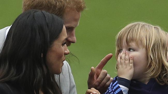 Prince Harry and Meghan played around with little Walter Cullen during their visit to Croke Park on the second day of their Ireland tour. Picture: Brian Lawless/PA via AP