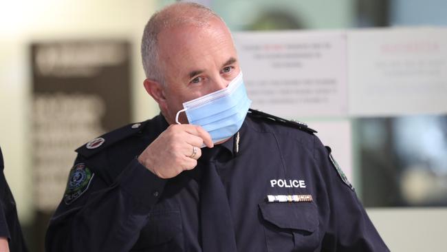 Assistant Police Commissioner Peter Harvey takes off this mask at the press conference. Picture: Tait Schmaal