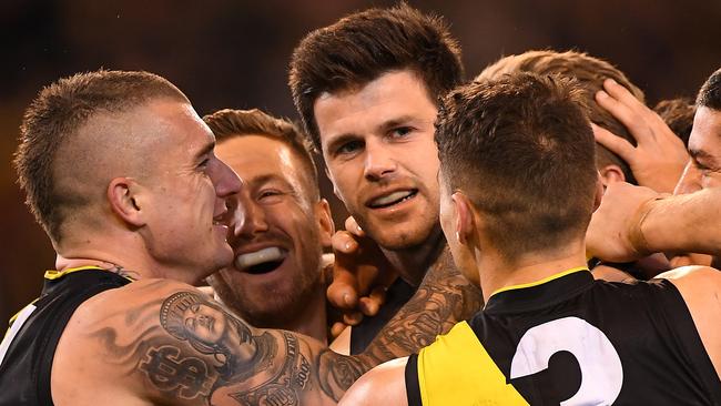 (L-R) Dustin Martin, Kane Lambert and Dion Prestia swamp Trent Cotchin after his final-term goal. Picture: AAP