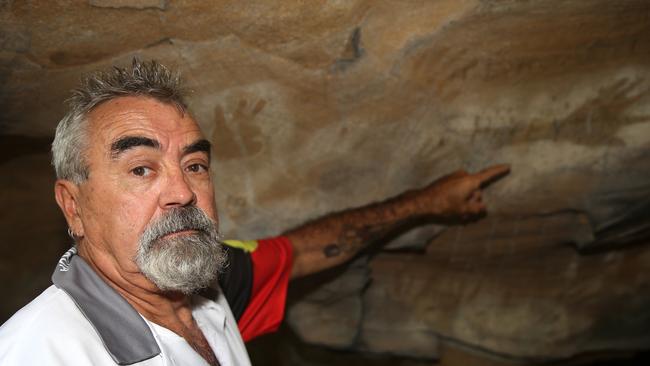 Wonnarua elder Uncle Warren Taggart at one of at least five Hunter Valley caves where thieves have chiselled out indigenous art dating back thousands of years. Picture by Peter Lorimer.