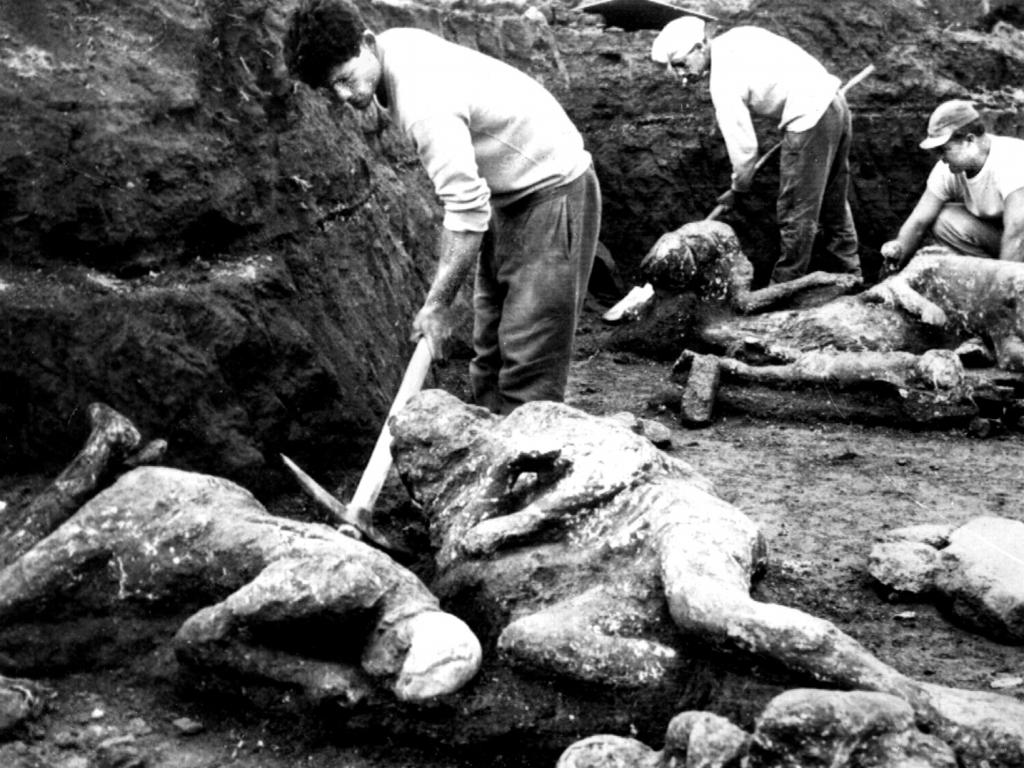 Workers clear away solidified ashes in 1961 from the ‘stone’ bodies.