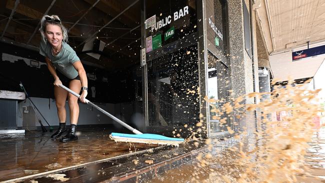 Wading through the now receding flood waters, Laani Winkler 25, helps friend Kylie Gilmore clean her flood ravaged pub in the central business district, for the second time in weeks at Lismore, in Northern NSW. Lyndon Mechielsen/The Australian