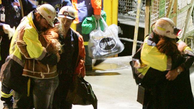 Tasmanian miners Todd Russell (R) and Brant Webb (L) hug family members after being rescued from Beaconsfield gold mine.