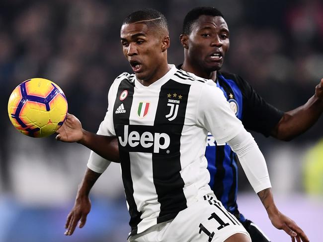 Juventus' Brazilian forward Douglas Costa (L) vies with Inter Milan's Ghanaian midfielder Kwadwo Asamoah during the Serie A soccer match Juventus vs InterMilan at the Stadio delle Alpi in Turin on December 7, 2018. (Photo by Marco BERTORELLO / AFP)