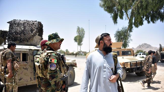 Afghan security personnel stand guard along the road in Kandahar amid ongoing fight against Taliban fighters. Picture: AFP