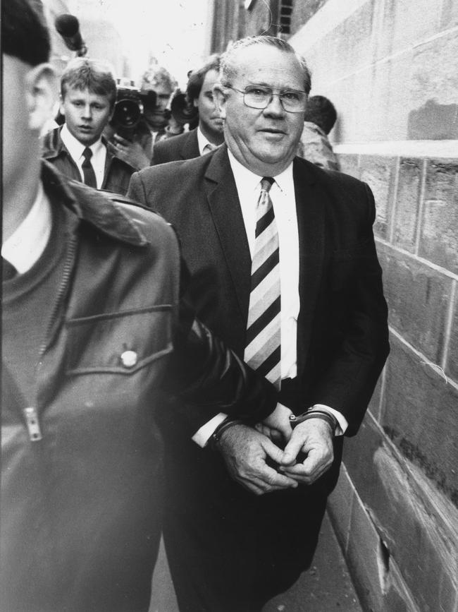 Former NSW Corrective Services Minister Rex Jackson is led into court in handcuffs on 1 September 1987.