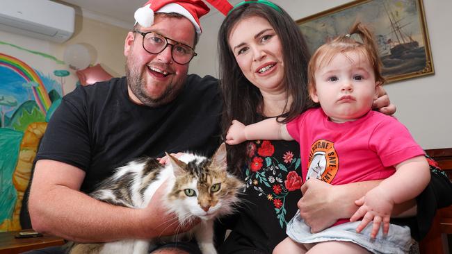 Kate Swanson, Luke Milroy, their cat John Snow and daughter Murphy. Picture: Brendan Beckett