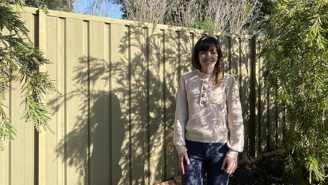 Arlene Blane at her back fence which is a stone’s throw from roaring trucks.