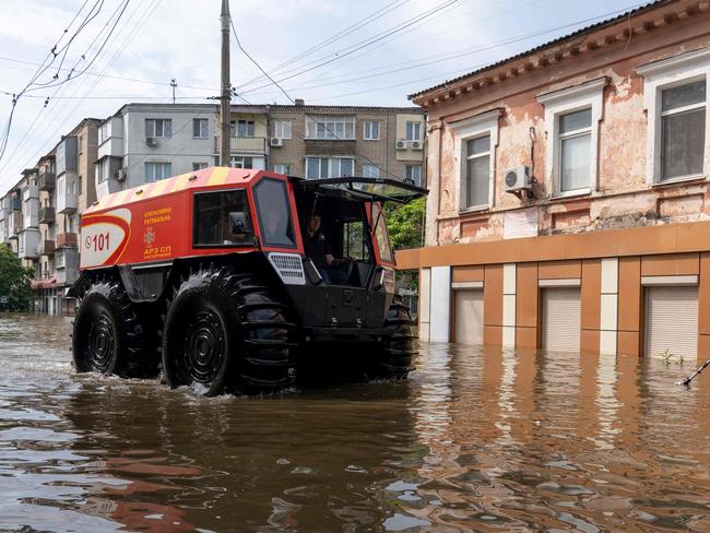 Rescuers ride an all-terrain vehicle during an evacuation from a flooded area in Kherson following damages sustained at Kakhovka hydroelectric power plant dam. Picture: AFP