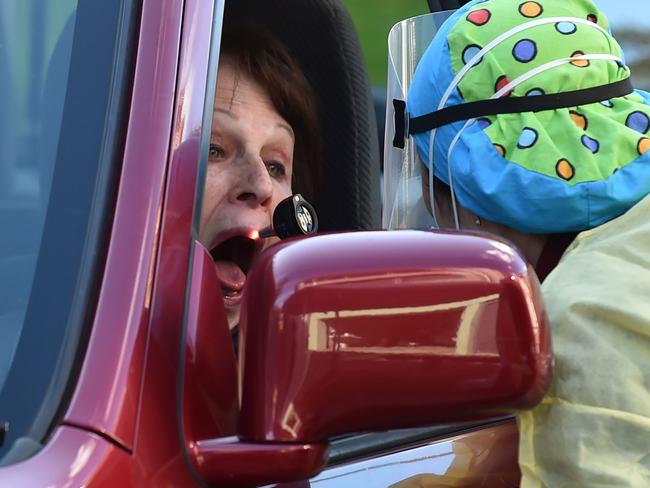 A medic checks a woman's throat at a drive-through testing centre for the COVID-19 coronavirus in Sydney on July 30, 2020. (Photo by PETER PARKS / AFP)