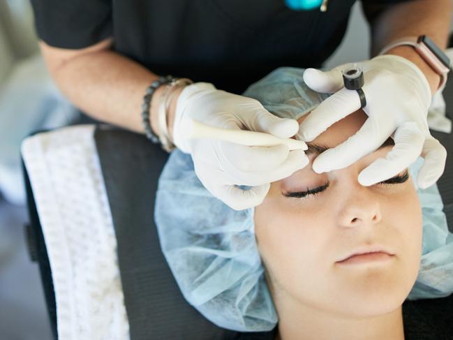 Shot of a young woman getting her eyebrows microbladed . eyebrows brows technician istock