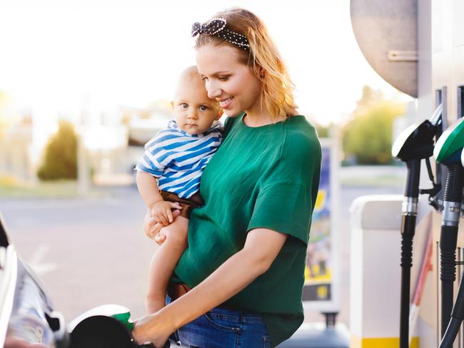 ESCAPE:  Young mother with baby boy at the petrol station refuelling the car. Picture: Istock