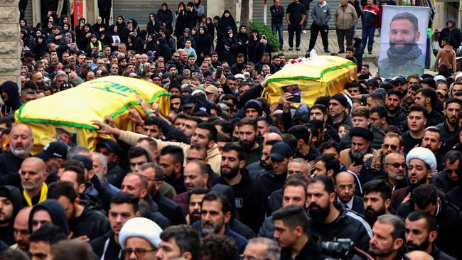 Mourners carry the coffins of a Hezbollah fighter and of one of his relatives who were killed in Israeli bombardment the previous night, during a funeral procession in Bint Jbeil, in southern Lebanon near the border with Israel, on December 27, 2023, amid ongoing cross-border tensions as fighting continues between Israel and Hamas militants in Gaza. An Israeli air strike on a south Lebanon border town killed a Hezbollah fighter, the group said on December 27, with state media reporting two of his relatives were also killed. (Photo by AFP)