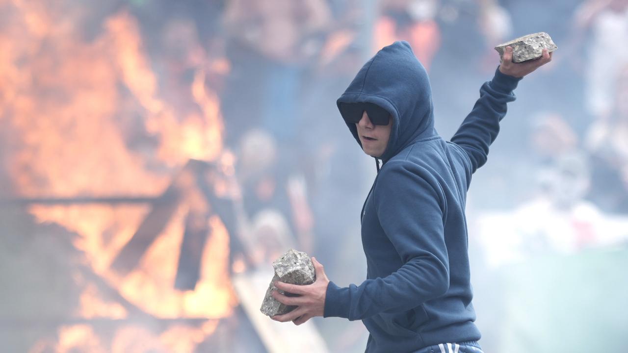 A protester prepares to throw a piece of concrete during riots outside of the Holiday Inn Express in Manvers. Picture: Getty Images