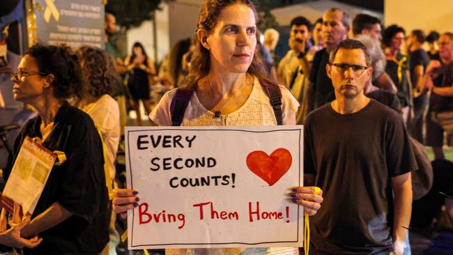 A woman holds a sign while standing with other protesters blocking traffic during a demonstration in solidarity with the Israeli hostages held by Palestinian militants since the October 7 attack, in the centre of Tel Aviv on October 24, 2023. Picture: Ahmad Gharabli/AFP