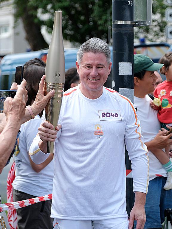 Mr Sneesby carries the Paris Olympics torch in the relay. Picture: Jaacquelin Magnay.