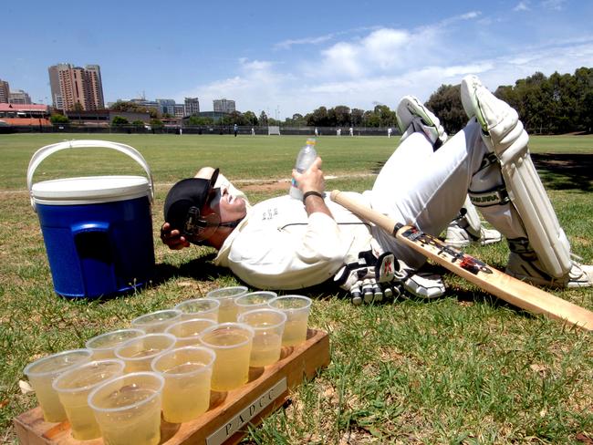 Hot summer weather at district cricket - Port Adelaide D-grade cricketer Dean Leone, 36, covered in zinc cream, grabs a cool drink before his turn at the crease to bat playing against Southern Districts at Adelaide Oval No. 2 ground.