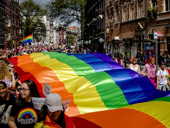 A rainbow flag is carried during a Pride Walk through Amsterdam, the Netherlands, to raise awareness of LGBTIQ rights. Picture: AFP Photo