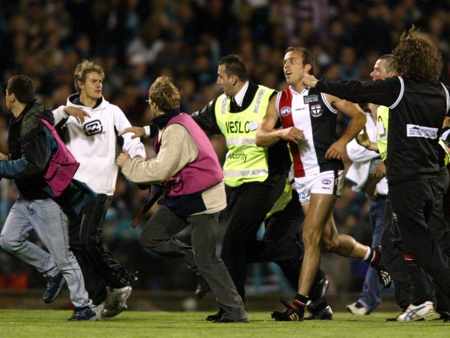 Footballer Fraser Gehrig is mobbed after kicking his 100th goal in 2004.