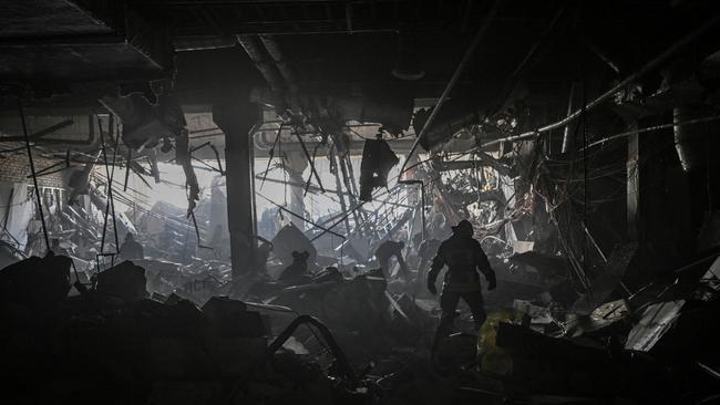 A Ukranian serviceman walks between debris inside the Retroville shopping mall. Picture: AFP