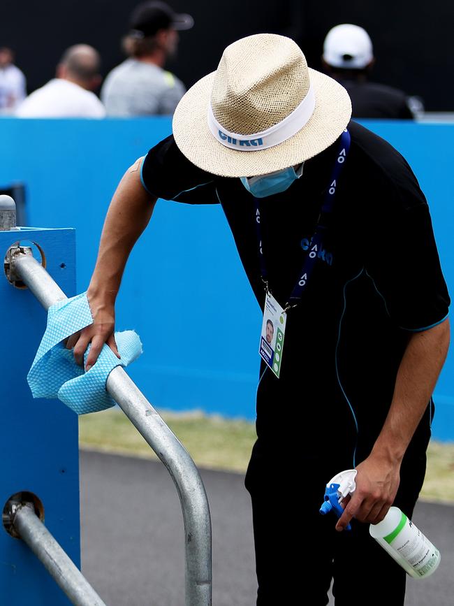 A staff member sanitises hand rails at Melbourne Park. Picture: Getty Images