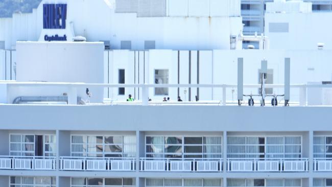 Queensland Police on the rooftop of the Double Tree Hilton hotel on the Cairns Esplanade, where a stolen helicopter on an unauthorised flight crash landed at about 1:50am Monday, killing the pilot. Picture: Brendan Radke