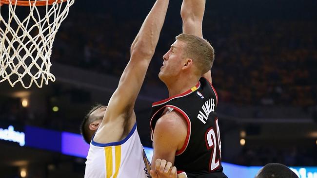 Andrew Bogut of the Golden State Warriors blocks a dunk attempt by Mason Plumlee of the Portland Trail Blazers.
