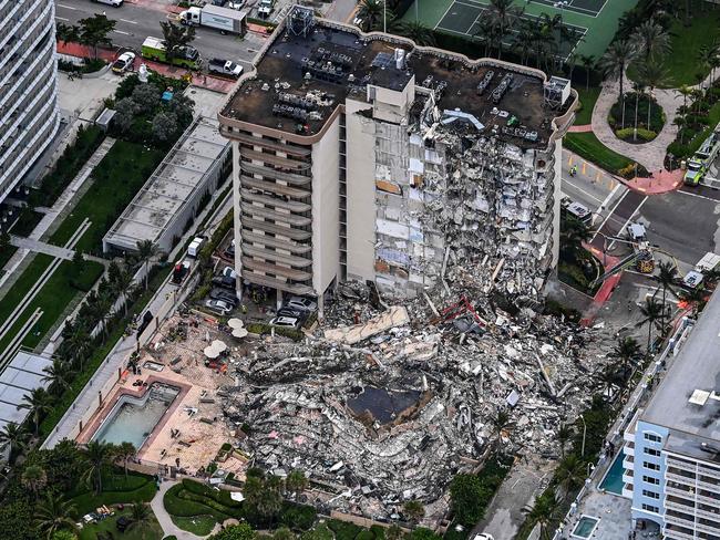 This aerial view, shows search and rescue personnel working on site after the partial collapse of the Champlain Towers South in Surfside, north of Miami Beach, on June 24, 2021. - The multi-story apartment block in Florida partially collapsed early June 24, sparking a major emergency response. Surfside Mayor Charles Burkett told NBCâs Today show: âMy police chief has told me that we transported two people to the hospital this morning at least and one has died. We treated ten people on the site.â (Photo by CHANDAN KHANNA / AFP)