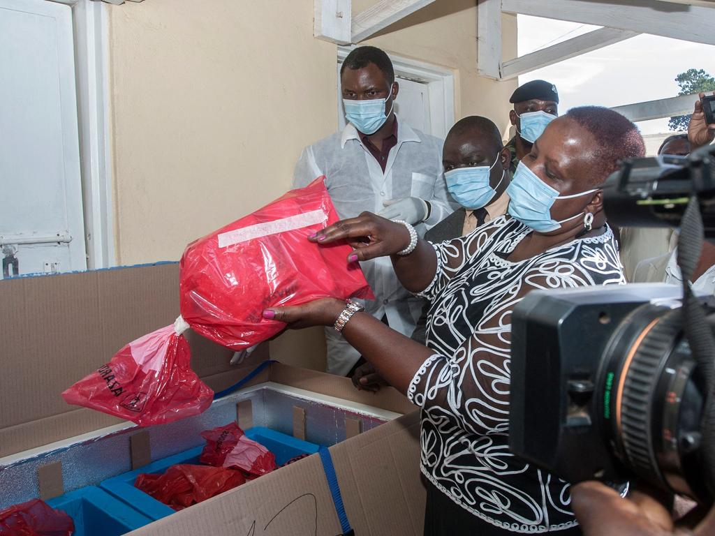 Malawi’s Health Minister Khumbize Kandodo Chiponda (C) lifts out a pack of expired COVID-19 Astra Zeneca from a transit box at an official ceremony at a pharmaceutical incinerator where the vaccines are to be destroyed. Picture: Amos Gumulira