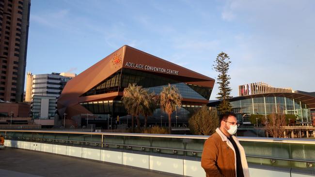 A man does the right thing and wears a mask as he walks past the Adelaide Convention Picture: Getty Images