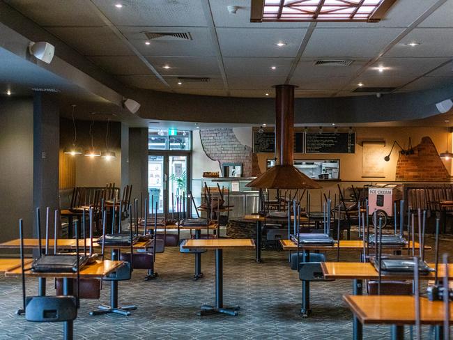 Tables and chairs in an empty bistro area is seen at the Notting Hill Pub in Melbourne.