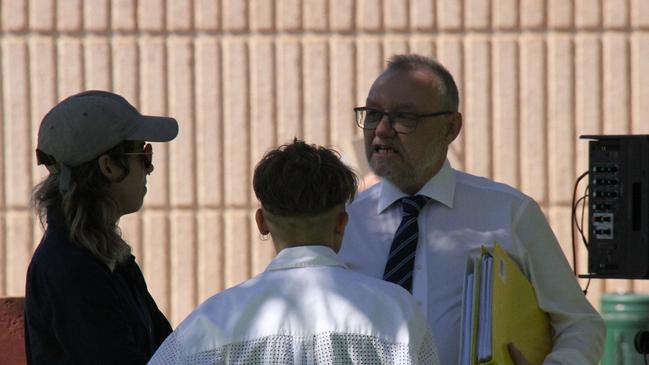 Carmen Escobar Robinson and Alexandra Elizabeth Walker talk to their defence lawyer John Lawrence outside the Alice Springs Local Court Tuesday, December 10. Picture: Gera Kazakov