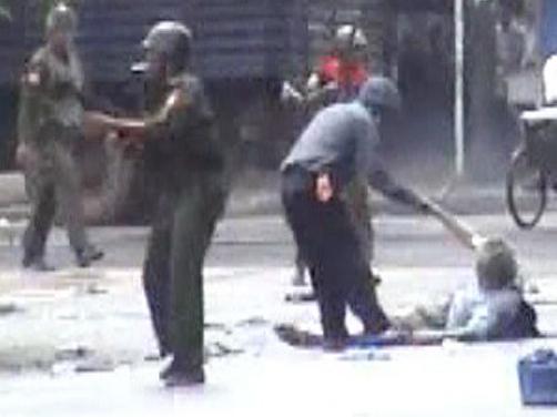 These four images taken from a video footage obtained by AFP 01 October 2007 with the Democratic Voice of Burma, shows The body of video journalist Kenji Nagai being dragged by a Myanmar riot police member in Yangon 27 september 2007. The body of video journalist Kenji Nagai bore signs that he was shot at point-blank range and died almost instantly, according to his employer who saw his remains in hospital in the following days. AFP PHOTO / DEMOCRATIC VOICE OF BURMA / MYANMAR OUT