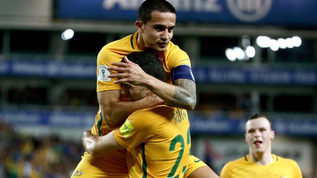 Tim Cahill celebrates a goal with Tom Rogic.