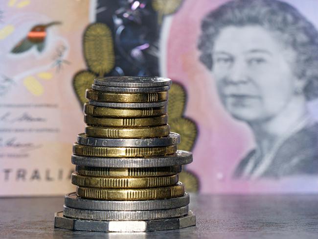 Australian coins stacked in front of an Australian five dollar bill in a panoramic format with image distortion. The new issue is designed to deter counterfeiting, the note is polymer and water resistant. cash money generic