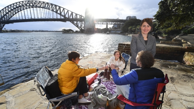 Patrick Slocombe, Max Mazaraki and Rosie O'Shea gather together at Mary Booth Lookout Reserve in Kirribilli for a champagne and oyster picnic alongside a life sized cardboard cutout of Premier Gladys Berejiklian on Monday after COVID-19 restrictions eased slightly for fully vaccinated residents. Picture: Getty Images
