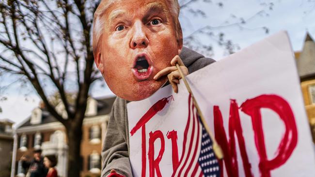 A supporter of US President Donald Trump holds a Trump mask during a protest in St Paul, Minnesota, on Saturday. Picture: AFP