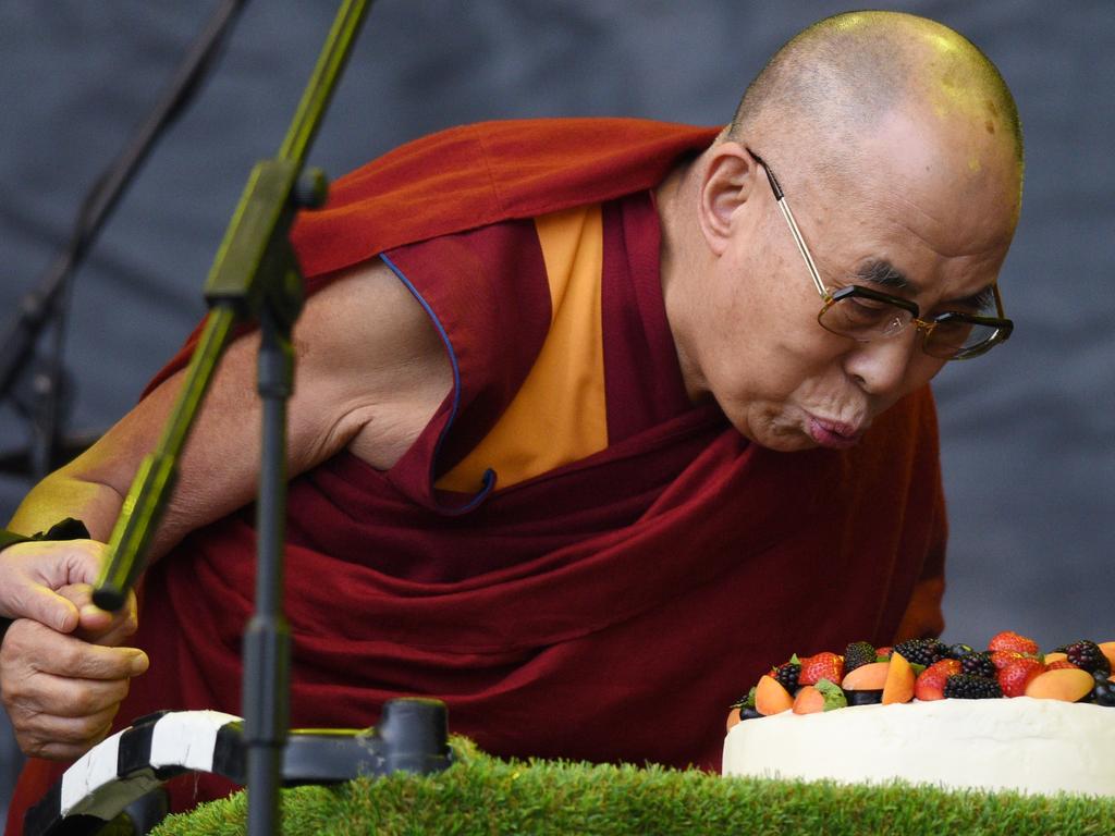 The Dalai Lama blows out a candle on a cake to celebrate his 80th birthday on the pyramid stage as he visits the 2015 Glastonbury Festival . Picture: AFP